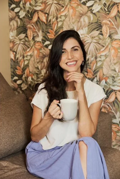Jaque Barbosa sorrindo com uma xícara nas mãos